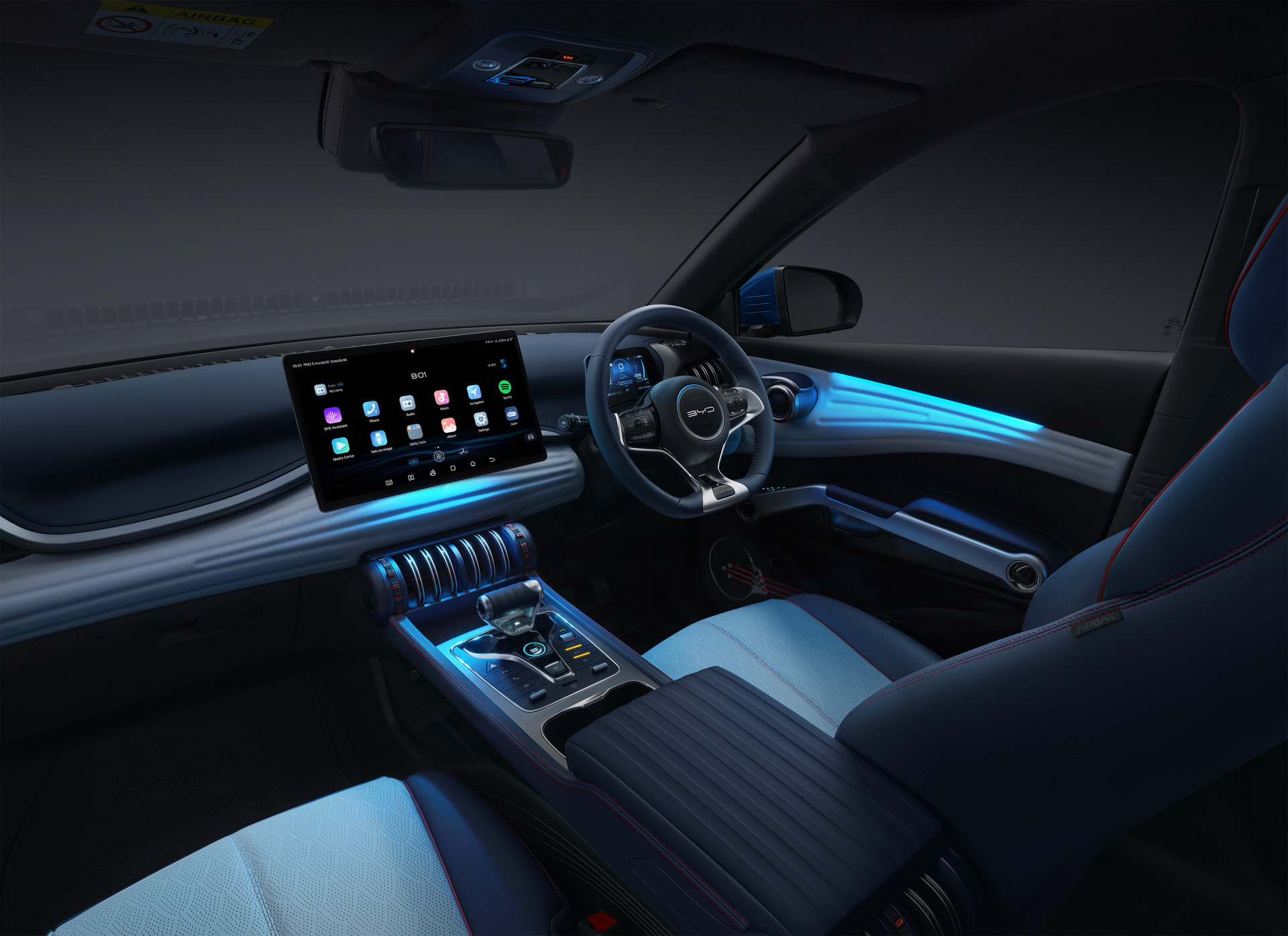 A wide angle photograph of the interior of the BYD Atto 3 showing the front cabin at night with interior ambient lighting